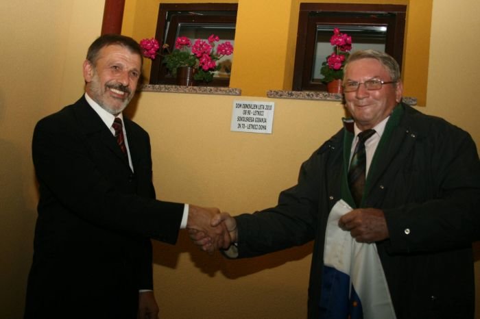 Predsednik gradbenega odbora za obnovo doma Jure Šlogar in Roman Novšak sta na koncu petkove prireditve odkrila spominsko ploščo na TVD Partizanu.