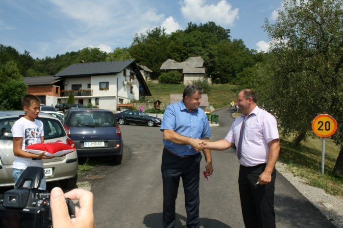 Predsednik gradbenega odbora Milan Jamšek (levo) in predsednik KS Šentjanž Boštjan Krmelj sta prerezala trak na obnovljeni cesti.(Foto: M. L.)
