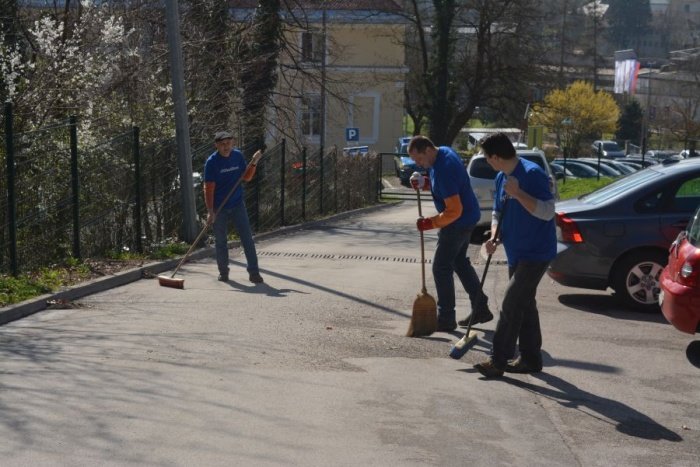 Zavarovalnica Sava v akciji: višje so zaposlene urejale cvetlične gradice, nižje so zaposleni pometali dovoz in parkirišče.
