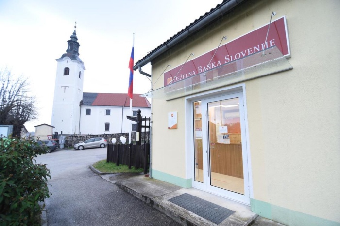 Nova poslovalnica Deželne banke Slovenije stoji ob glavni cesti skozi Škocjan, ob poštni poslovalnici.