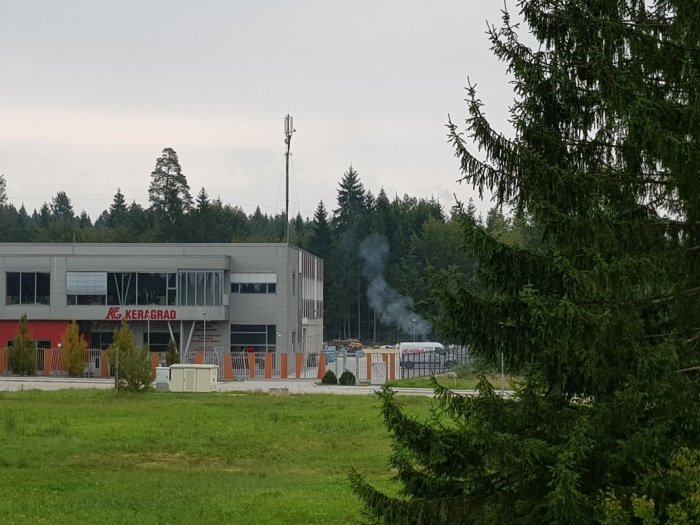 Podjetje Keragrad in dim, ki se dviga s kurišča ob stavbi na fotografiji, ki nam jo je poslala stanovalka naselja Podbreznik.