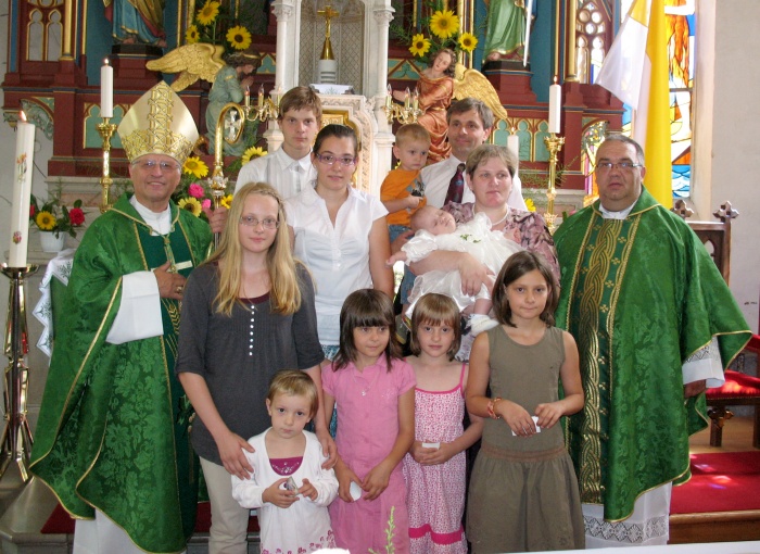 Družina Koprivc leta 2011 ob krstu hčerke Mance (na levi novomeški škof  msgr. Andrej Glavan). Zaradi razmer v povezavi z novim koronavirusom je  podelitev odličja namreč prestavljena na poznejši čas, verjetno na eno  od majskih nedelj v dolenjskem romarskem središču Zaplaz.