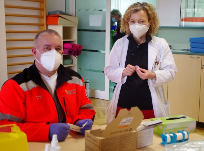 Direktorica ZD NM Alenka Simonič s svojim pomočnikom za zdravstveno nego Petrom Černetom, ki pripravlja cepivo.