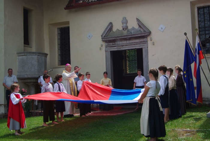 Blagoslov slovenske zastave, ki so jo prinesli škocjanski otroci v nošah.