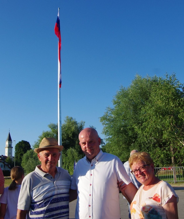 Slavko Pirh s staršema, v ozadju slovenska zastava velikanka.