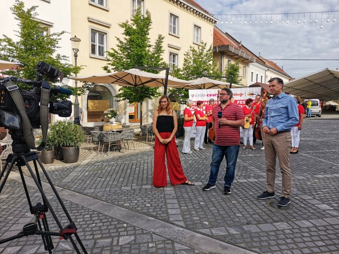 Novomeški Glavni trg je že zjutraj obiskala tudi ekipa Planet tv in župan Gregor Macedoni je gledalce vabil na rdeče obarvani festival ... (Foto: MO NM FB)