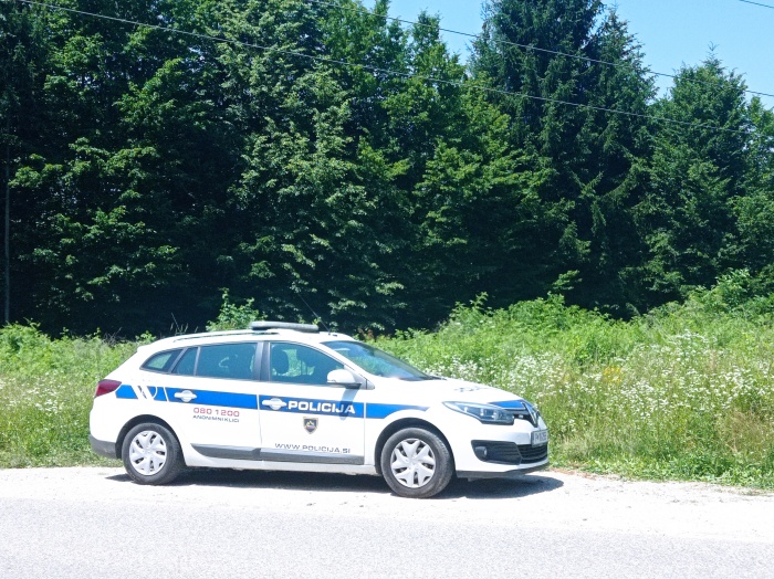 Policijski avto danes v bližini najdbe, kamor se bodo kriminalisti še vrnili. Truplo so našli v gozdu med velodromom in rondojem pri Adrii Mobil, razmeroma blizu ceste ... (Foto: B. B.)