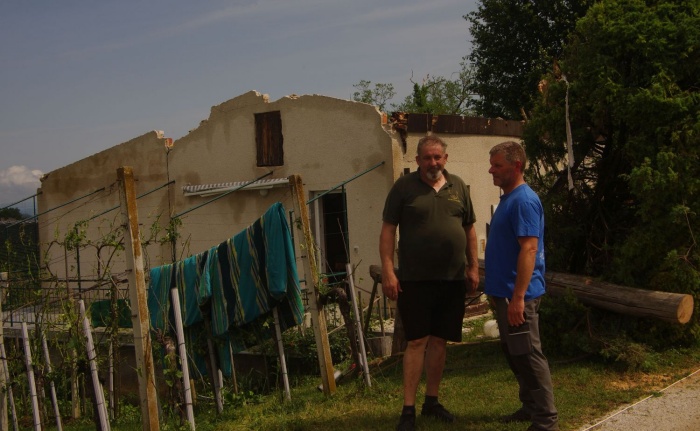 Jože s prijateljem Jurijem Krštincem pred hišo, ki je ostala brez strehe.
