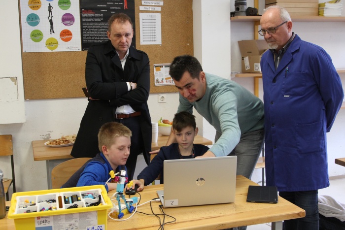 Učitelja Uroš Strugar (v sredini) in Dušan  Plut (desno) sta skupaj z učenci donatorju Robertu Medletu predstavila  delo z Legovimi roboti. (Foto: I. Vidmar)